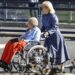 Caregiver Pushing Woman in Wheelchair
